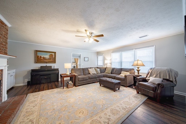 living room with visible vents, ornamental molding, wood finished floors, baseboards, and a brick fireplace