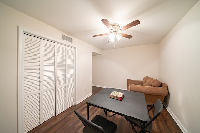 office area with visible vents, ceiling fan, dark wood-type flooring, and baseboards