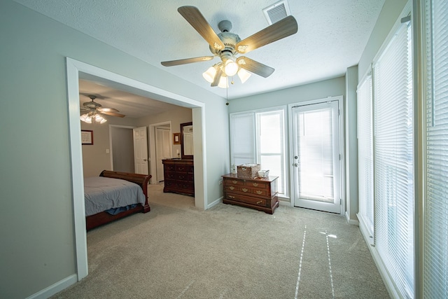 carpeted bedroom featuring access to exterior, visible vents, a textured ceiling, and baseboards