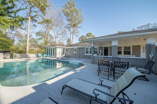 view of pool with a ceiling fan, fence, a sunroom, a fenced in pool, and a patio area