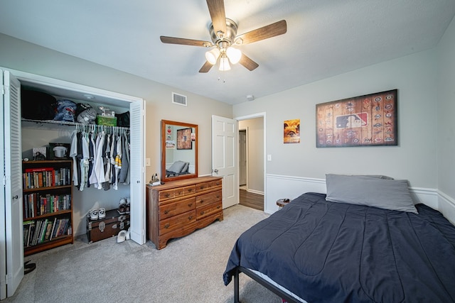 carpeted bedroom with a ceiling fan, visible vents, and a closet