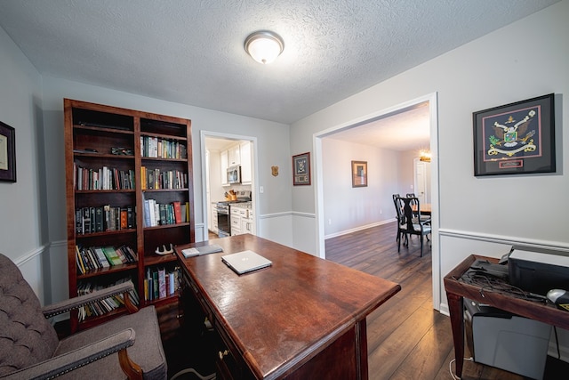 office area featuring baseboards, a textured ceiling, and dark wood finished floors