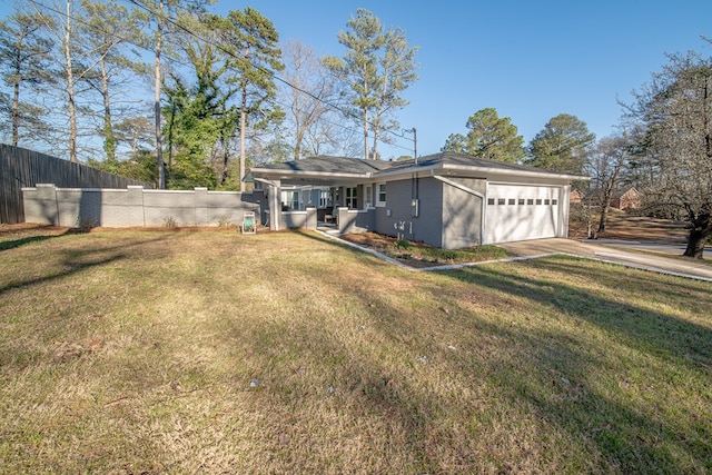 back of property with a garage, a lawn, brick siding, and fence