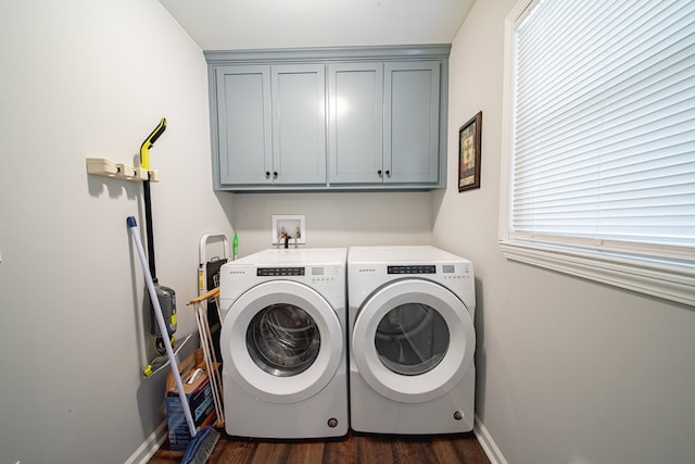 clothes washing area featuring cabinet space, washing machine and dryer, baseboards, and dark wood-style flooring