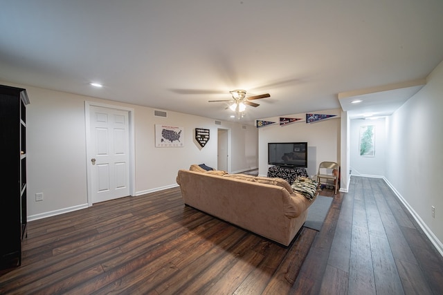 living area featuring ceiling fan, dark wood-style floors, visible vents, and baseboards