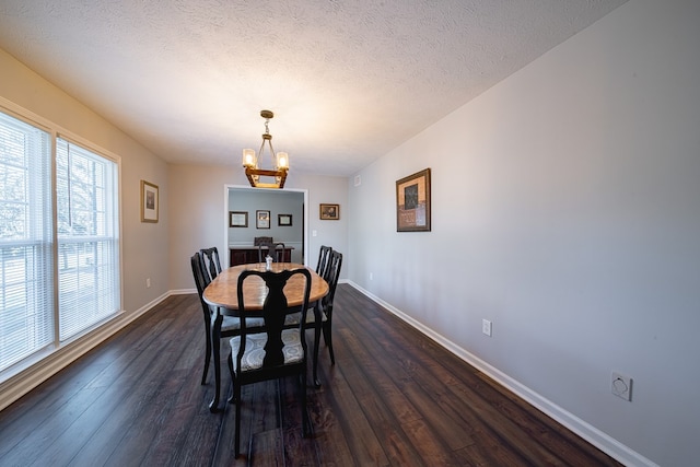 dining area with baseboards, a notable chandelier, dark wood-style floors, and a textured ceiling