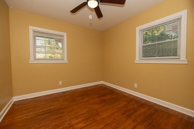 spare room featuring ceiling fan, wood finished floors, visible vents, and baseboards