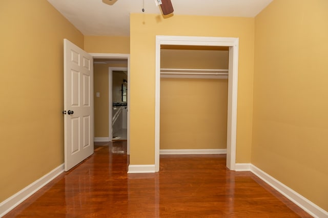 unfurnished bedroom featuring ceiling fan, a closet, wood finished floors, and baseboards