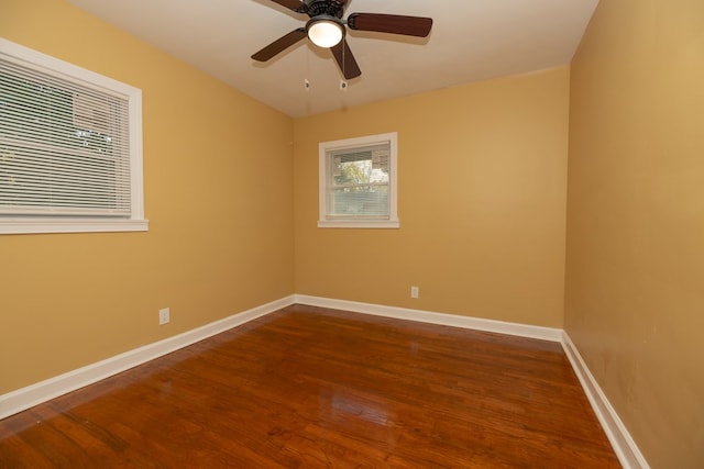 empty room featuring a ceiling fan, baseboards, and wood finished floors