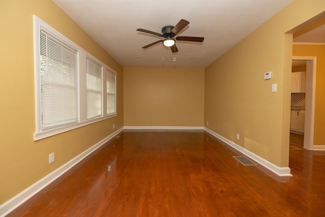 empty room featuring visible vents, baseboards, ceiling fan, and wood finished floors