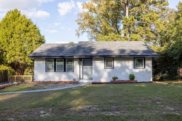 ranch-style house with a front yard and brick siding