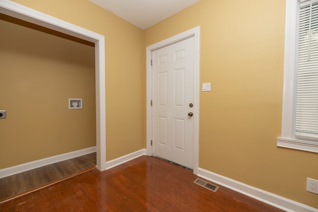 foyer entrance featuring dark wood-style floors, visible vents, and baseboards