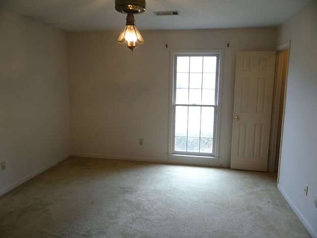 spare room featuring carpet flooring, baseboards, and visible vents