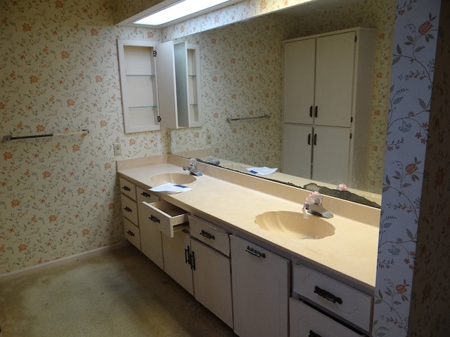 full bathroom with double vanity, wallpapered walls, baseboards, and a sink