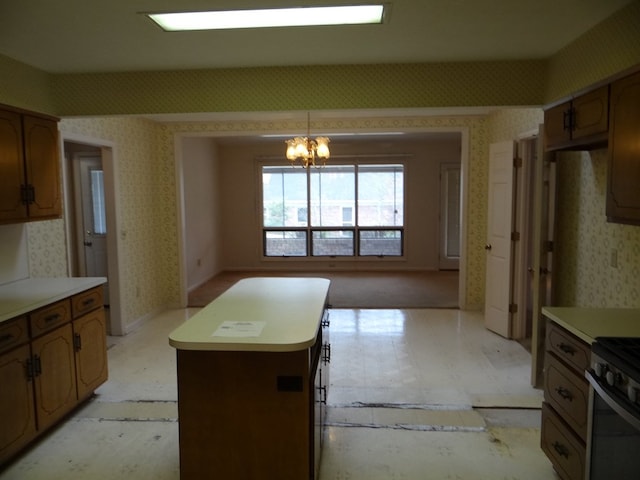 kitchen with a kitchen island, wallpapered walls, light floors, light countertops, and a notable chandelier