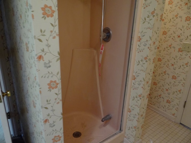 full bath featuring tile patterned floors, baseboards, and a stall shower