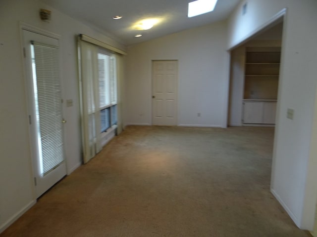 interior space with light colored carpet, baseboards, and lofted ceiling