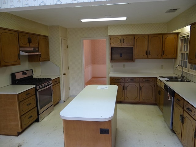 kitchen with wallpapered walls, under cabinet range hood, light floors, and appliances with stainless steel finishes