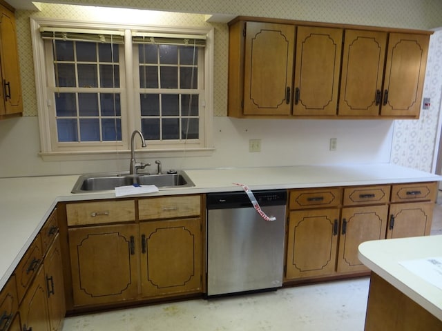 kitchen with dishwasher, brown cabinets, and a sink