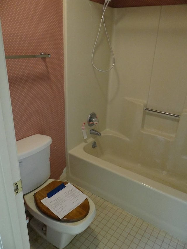 full bathroom with tile patterned flooring, toilet, and washtub / shower combination