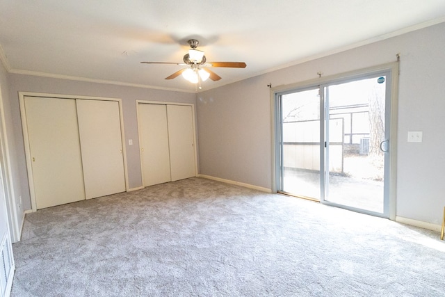 unfurnished bedroom with light colored carpet, access to outside, ornamental molding, two closets, and ceiling fan