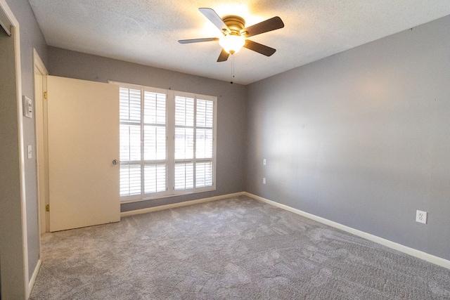 carpeted spare room with ceiling fan and a textured ceiling