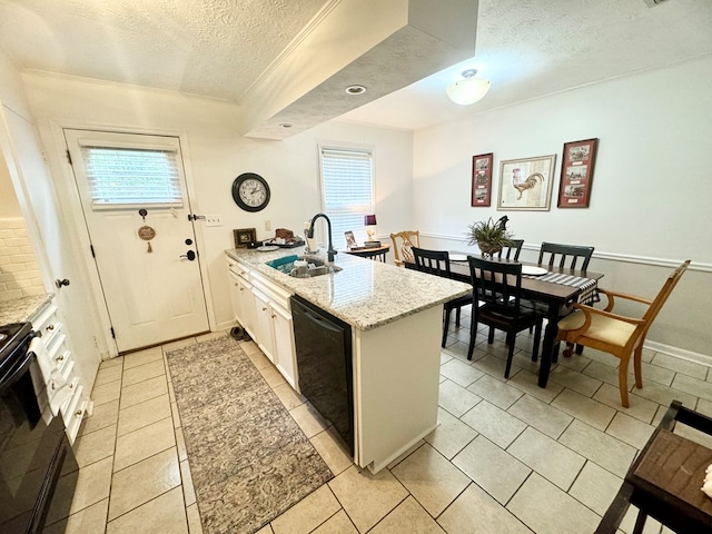 kitchen featuring a wealth of natural light, sink, black appliances, and a textured ceiling