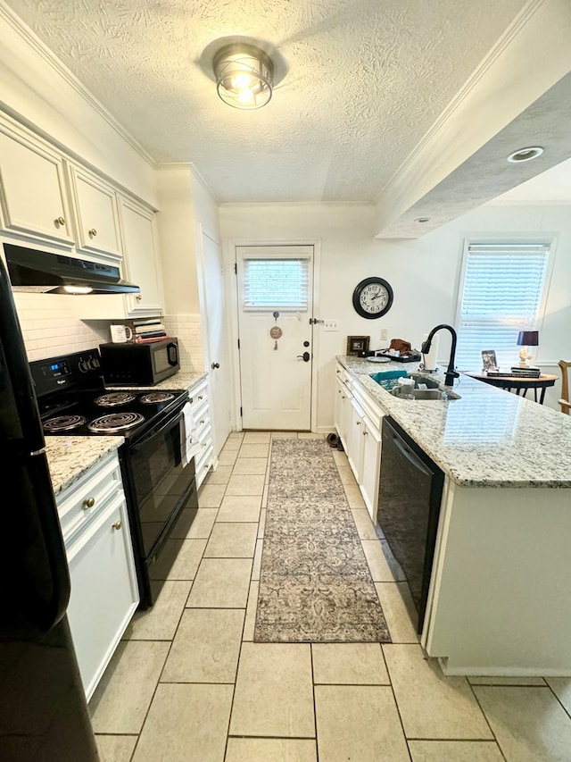 kitchen with black appliances, light stone counters, light tile patterned floors, and sink