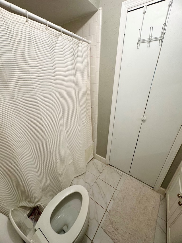 bathroom featuring walk in shower and toilet