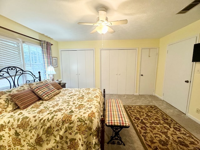 bedroom featuring multiple closets, ceiling fan, and a textured ceiling