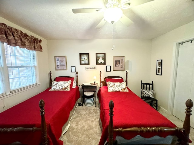 carpeted bedroom featuring ceiling fan and a textured ceiling