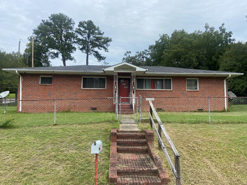 single story home featuring a front lawn