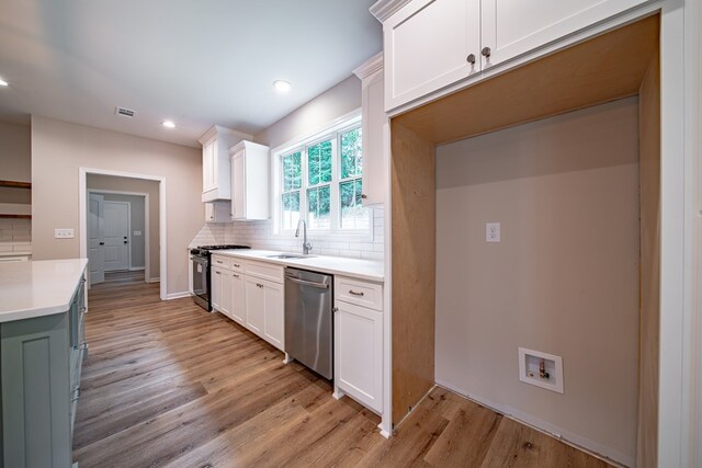 821 Lichfield Rd, Columbus, GA 31904 - kitchen with stainless steel appliances, decorative backsplash, light wood-type flooring, light countertops, and white cabinets