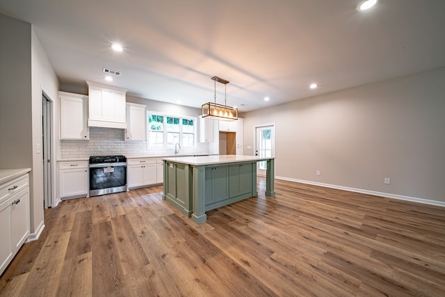 821 Lichfield Rd, Columbus, GA 31904 - kitchen with stove, white cabinetry, backsplash, a kitchen island, and light countertops