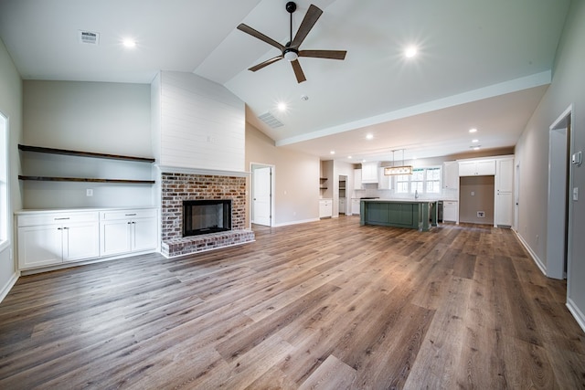 821 Lichfield Rd, Columbus, GA 31904 - unfurnished living room featuring ceiling fan, wood finished floors, a brick fireplace, lofted ceiling, and recessed lighting