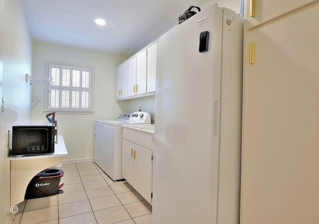 washroom with cabinet space, washing machine and dryer, and light tile patterned flooring