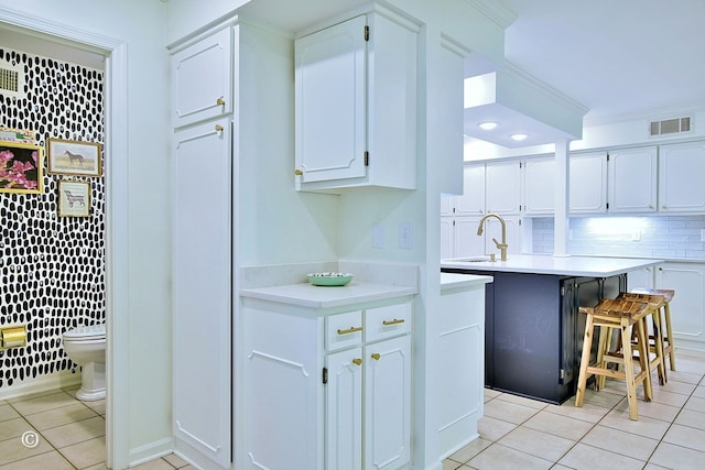 kitchen with light countertops, light tile patterned floors, visible vents, and white cabinetry