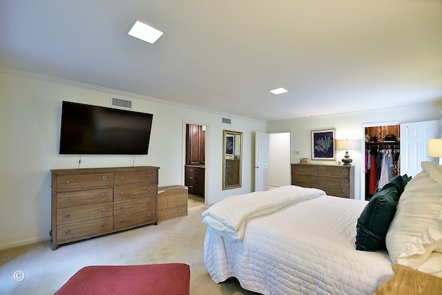 bedroom with light colored carpet, crown molding, visible vents, and a spacious closet