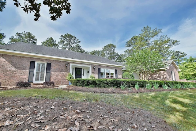 ranch-style home featuring a front lawn and brick siding