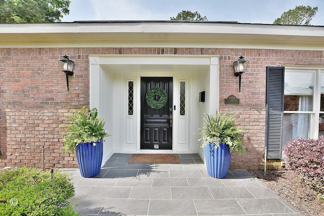 property entrance featuring brick siding
