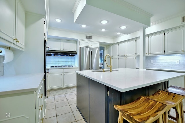 kitchen featuring decorative backsplash, high end fridge, visible vents, and a sink
