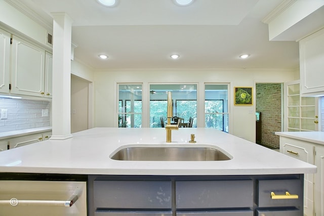 kitchen with light countertops, a sink, crown molding, dishwasher, and tasteful backsplash