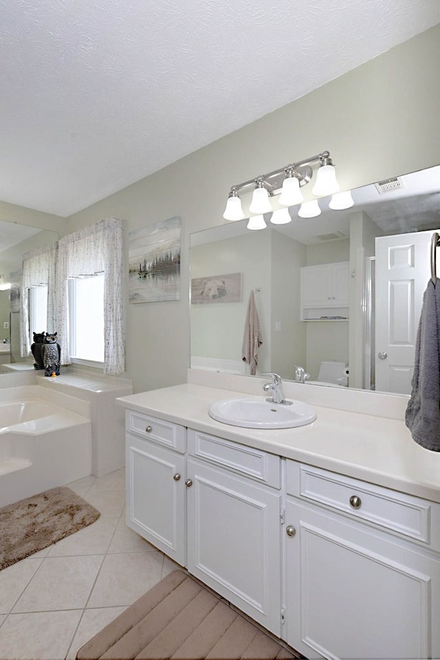 bathroom with vanity, tile patterned flooring, a garden tub, and visible vents