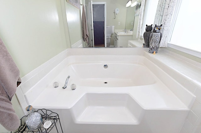 full bathroom with a garden tub and vanity