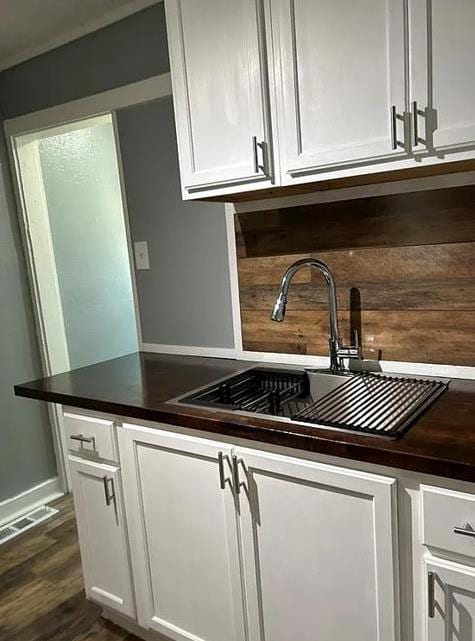 kitchen featuring white cabinetry, sink, and dark wood-type flooring