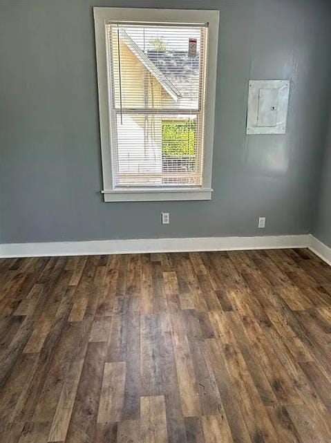 spare room with dark hardwood / wood-style flooring and electric panel