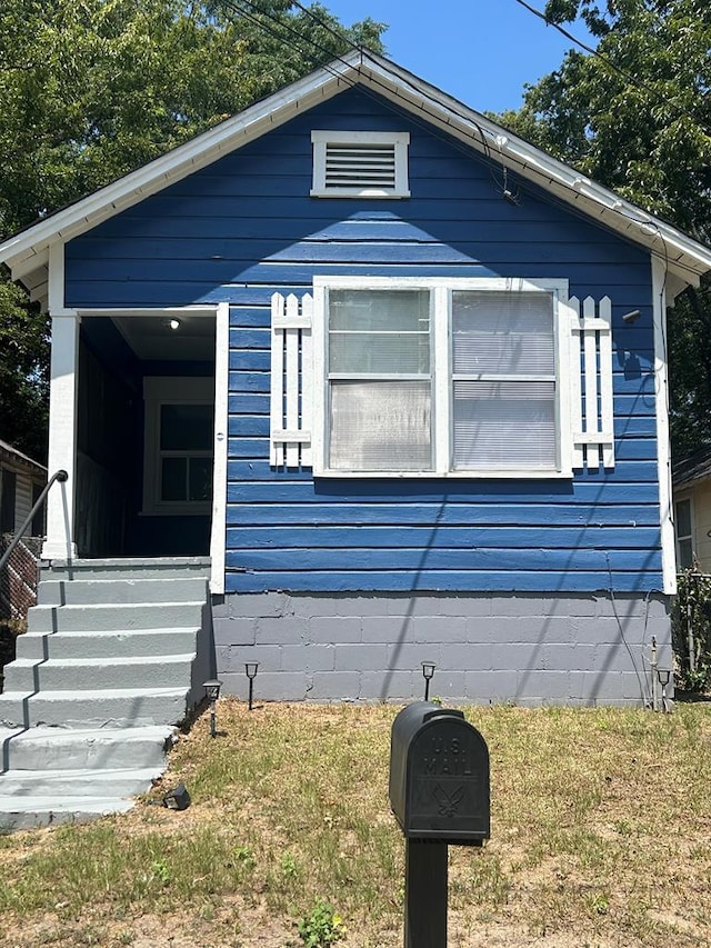 bungalow-style home with a front lawn