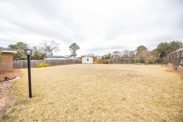 view of yard featuring a fenced backyard, an outdoor structure, and a shed