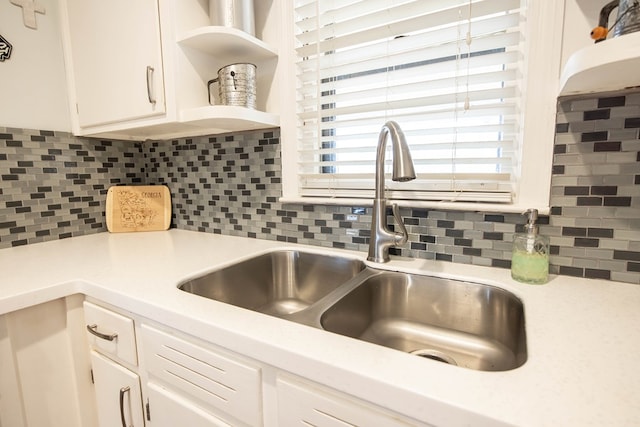 kitchen featuring white cabinetry, open shelves, a sink, and light countertops