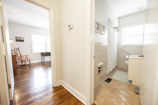 bathroom featuring tile walls, curtained shower, visible vents, toilet, and wood finished floors